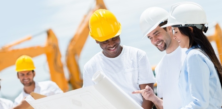 Female and male workers looking at plans on a work site wearing PPE.jpeg